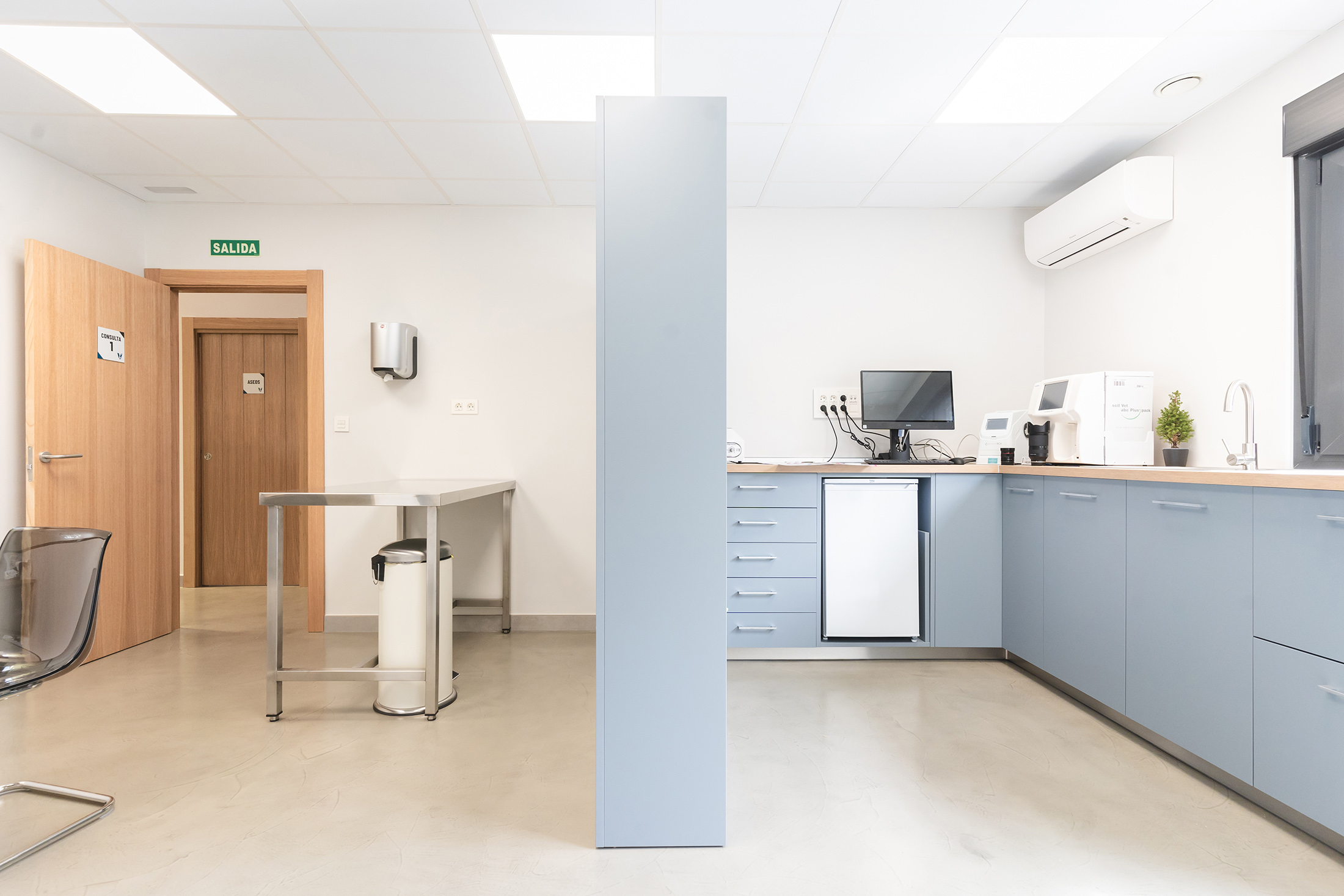 Sala interior luminosa y blanca con mobiliario de almacenaje y zona de trabajo